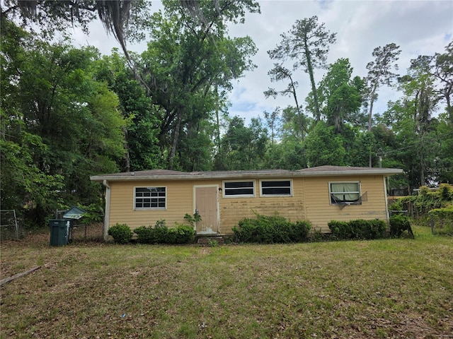 view of front of home with a front yard and fence