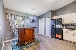 42 Dogwood Drive Crse, Ocala, FL 34472 - bar featuring black refrigerator with ice dispenser, baseboards, light wood-type flooring, pendant lighting, and lofted ceiling