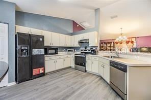 42 Dogwood Drive Crse, Ocala, FL 34472 - kitchen with an inviting chandelier, light wood-style flooring, light countertops, black appliances, and a peninsula