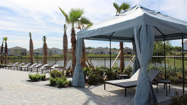 view of patio featuring a gazebo, fence, and a residential view