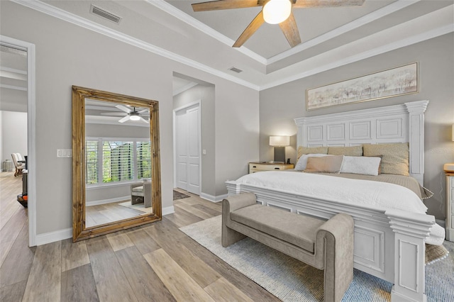 bedroom featuring light wood-style floors, visible vents, baseboards, and ceiling fan