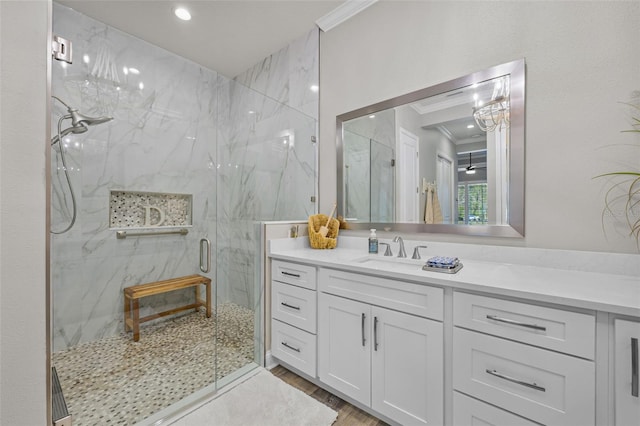 bathroom with ornamental molding, vanity, wood finished floors, and a marble finish shower