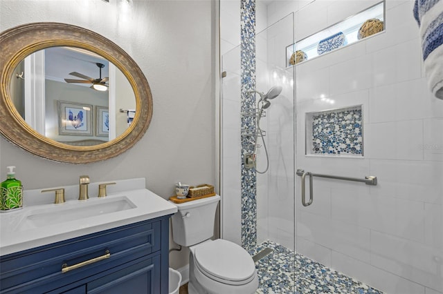 bathroom featuring toilet, a ceiling fan, vanity, and a stall shower