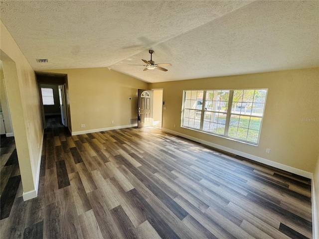 unfurnished living room with dark wood-style flooring, ceiling fan, a textured ceiling, and baseboards
