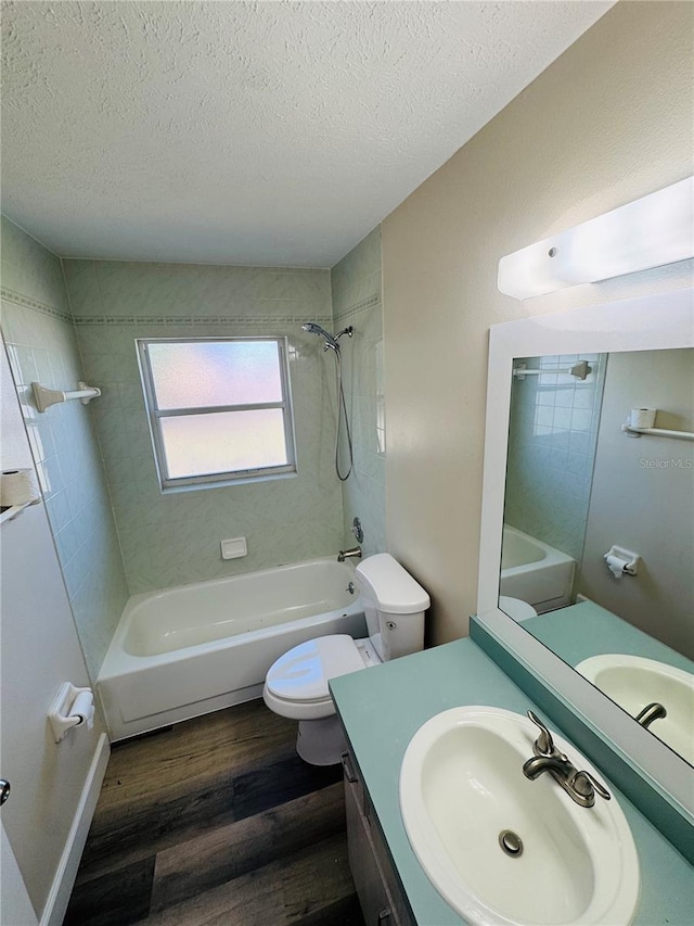 bathroom featuring washtub / shower combination, a textured ceiling, toilet, and wood finished floors