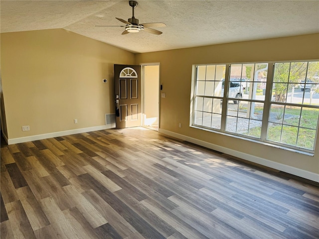 spare room with baseboards, wood finished floors, a ceiling fan, and vaulted ceiling
