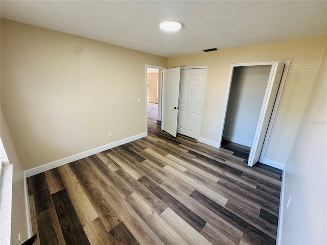 unfurnished bedroom featuring wood finished floors and baseboards