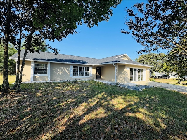 ranch-style home with stucco siding and a front yard
