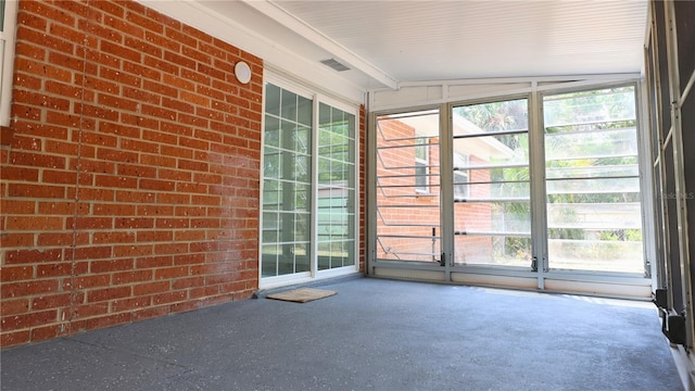unfurnished sunroom featuring visible vents and plenty of natural light