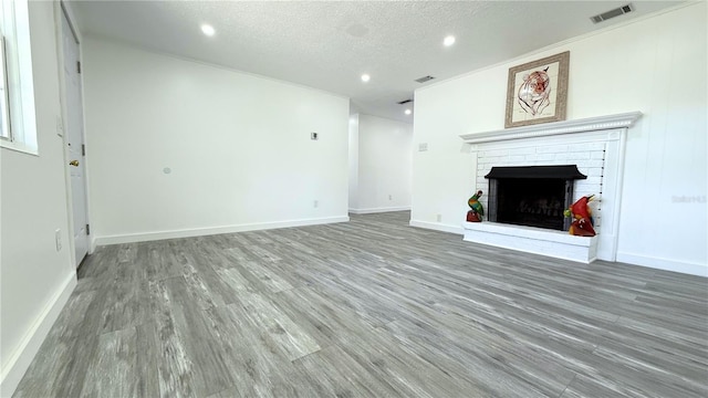 unfurnished living room featuring recessed lighting, visible vents, wood finished floors, and a fireplace