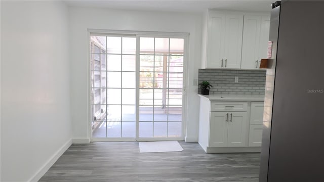 doorway featuring baseboards and wood finished floors