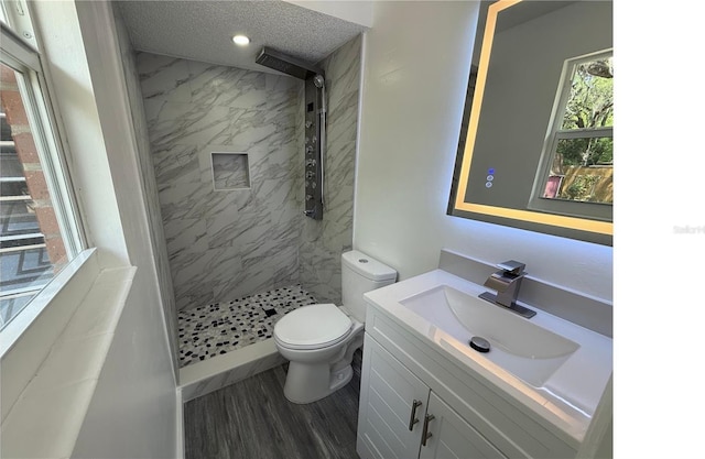bathroom featuring a stall shower, toilet, recessed lighting, wood finished floors, and vanity