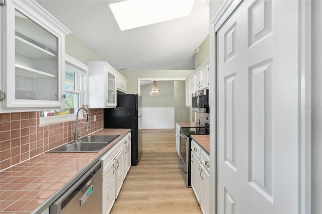 8 Banyan Dr, Ocala, FL 34472 - kitchen featuring appliances with stainless steel finishes, white cabinetry, a sink, tile counters, and light wood-style flooring