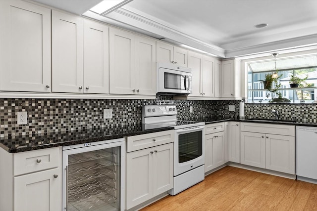 255 NW Bay Path Dr, Crystal River, FL 34428 - kitchen featuring tasteful backsplash, a sink, beverage cooler, white appliances, and light wood-style flooring