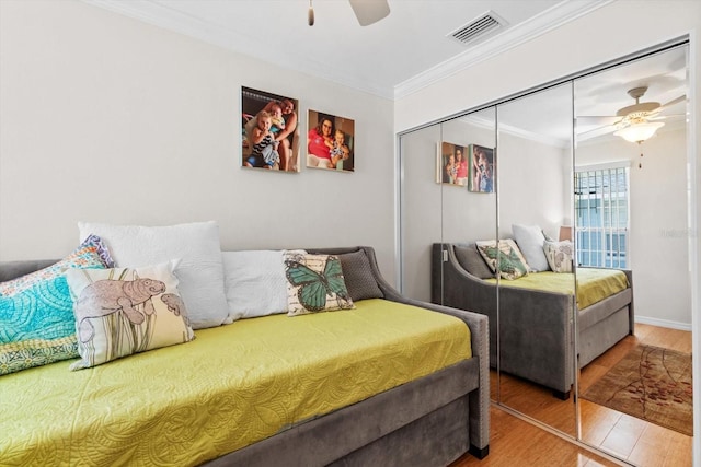 255 NW Bay Path Dr, Crystal River, FL 34428 - bedroom featuring visible vents, crown molding, a closet, wood finished floors, and a ceiling fan