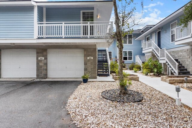 255 NW Bay Path Dr, Crystal River, FL 34428 - view of front of home with stairway, driveway, stone siding, and a garage