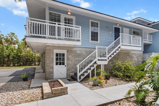 255 NW Bay Path Dr, Crystal River, FL 34428 - view of front facade with stairway, a balcony, and stone siding