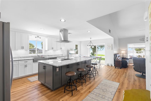 4237 Chambers St, Lake Wales, FL 33898 - kitchen featuring freestanding refrigerator, island exhaust hood, white cabinetry, a sink, and recessed lighting