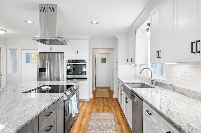 4237 Chambers St, Lake Wales, FL 33898 - kitchen featuring stainless steel appliances, island range hood, a sink, light wood-style flooring, and white cabinets