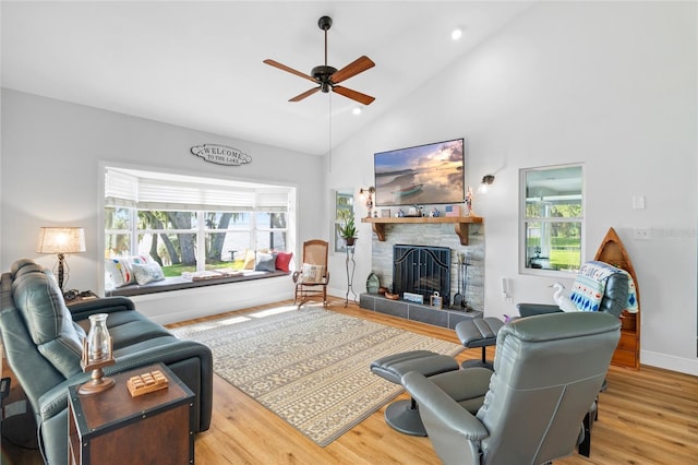 4237 Chambers St, Lake Wales, FL 33898 - living room with a tiled fireplace, ceiling fan, wood finished floors, baseboards, and high vaulted ceiling