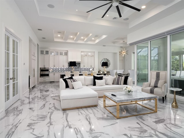 living room featuring recessed lighting, a ceiling fan, visible vents, and a raised ceiling