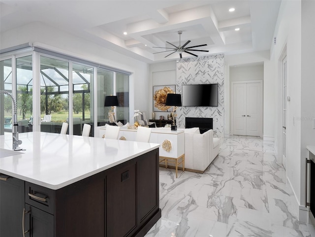interior space with recessed lighting, coffered ceiling, a large fireplace, light countertops, and ceiling fan