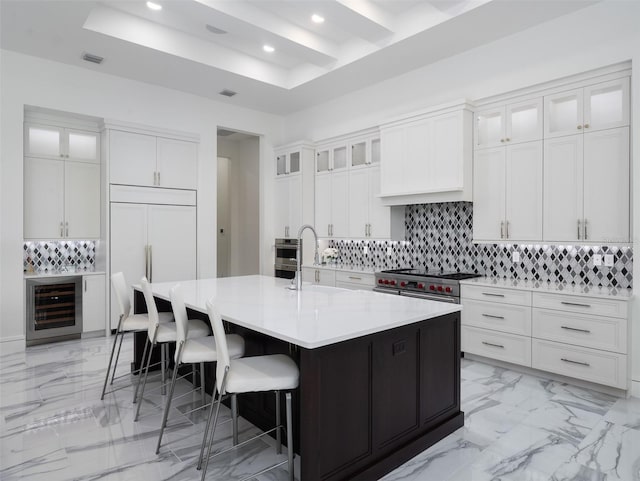 kitchen featuring wine cooler, decorative backsplash, white cabinets, and light countertops