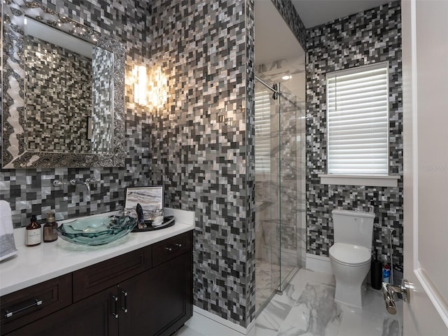 full bathroom featuring a stall shower, toilet, tile walls, vanity, and marble finish floor