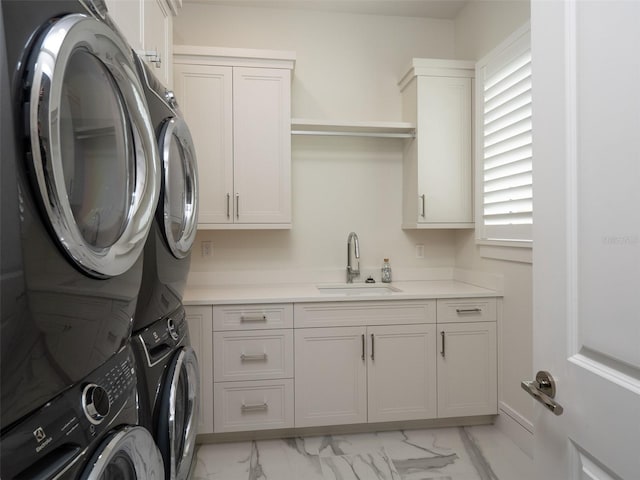 washroom featuring stacked washer / dryer, a sink, a healthy amount of sunlight, cabinet space, and marble finish floor