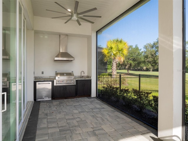 view of patio featuring a sink, fence, a grill, a ceiling fan, and exterior kitchen