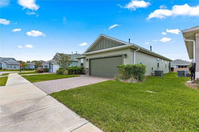view of front of house featuring driveway, board and batten siding, a front yard, and an attached garage