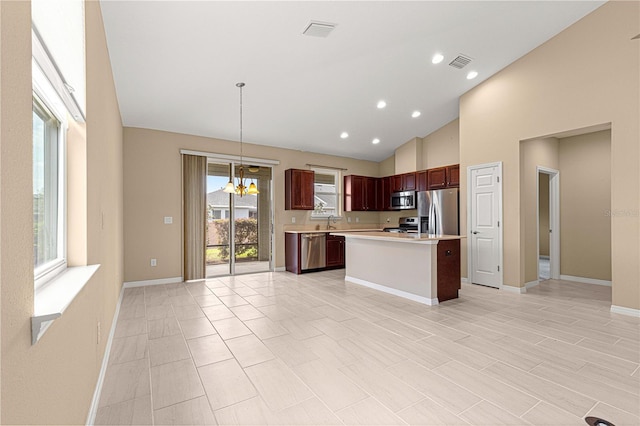 kitchen with appliances with stainless steel finishes, visible vents, light countertops, baseboards, and an inviting chandelier