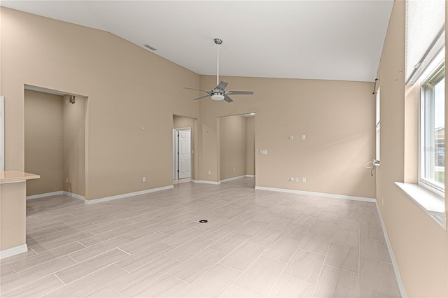 unfurnished room featuring light wood-type flooring, ceiling fan, vaulted ceiling, and baseboards
