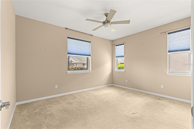 unfurnished room with a ceiling fan, carpet flooring, and baseboards