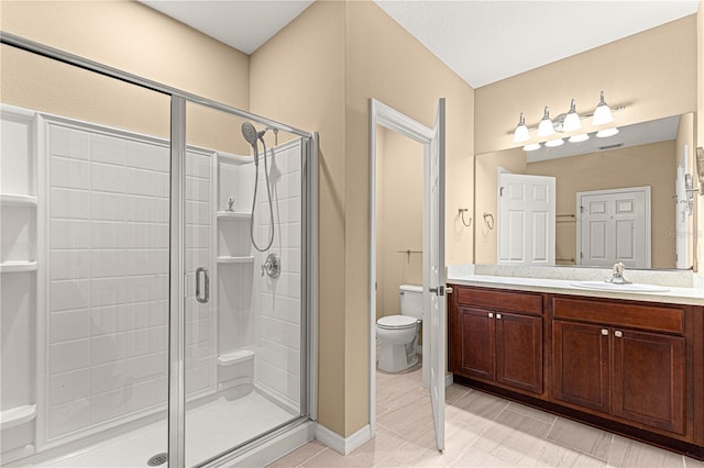 full bathroom featuring toilet, a shower stall, vanity, and baseboards