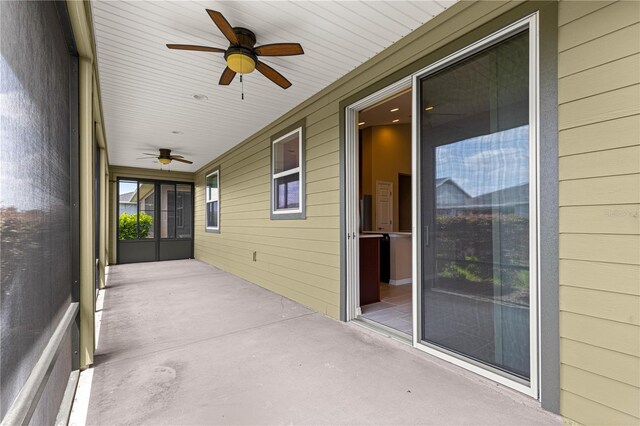 unfurnished sunroom featuring ceiling fan