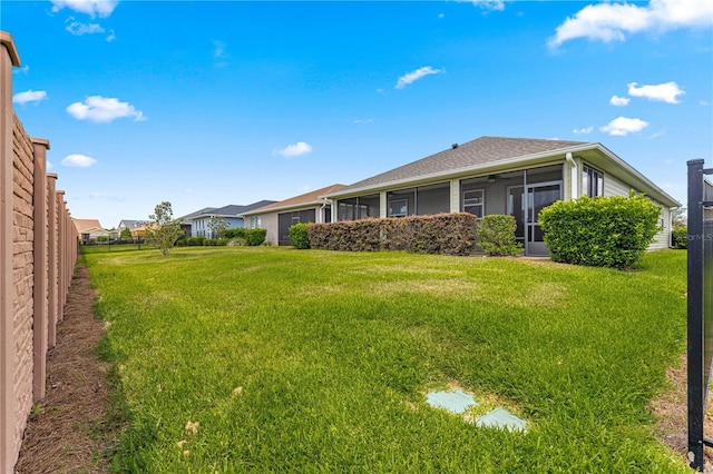 view of yard with fence and a sunroom