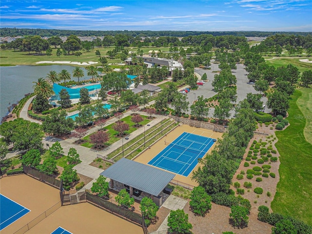 drone / aerial view with golf course view and a water view