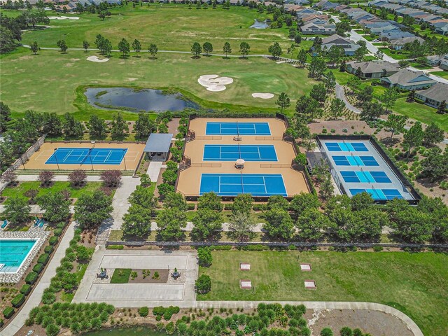 drone / aerial view featuring golf course view and a water view