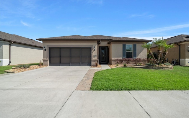 prairie-style house with a garage, a front lawn, stucco siding, and driveway