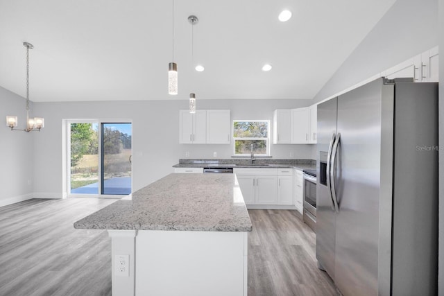 13493 SW 112th Pl, Dunnellon, FL 34432 - kitchen featuring appliances with stainless steel finishes, lofted ceiling, light wood-style flooring, plenty of natural light, and a chandelier