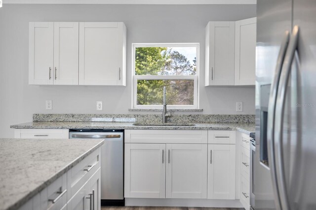 13493 SW 112th Pl, Dunnellon, FL 34432 - kitchen featuring stainless steel appliances, a sink, white cabinetry, and light stone counters