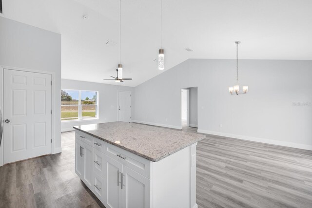 13493 SW 112th Pl, Dunnellon, FL 34432 - kitchen featuring vaulted ceiling, a chandelier, light wood-type flooring, white cabinetry, and light stone countertops
