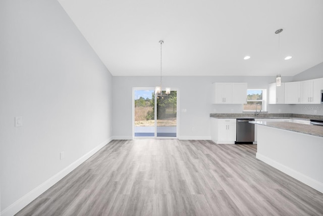 13493 SW 112th Pl, Dunnellon, FL 34432 - kitchen with stainless steel dishwasher, light wood-style floors, healthy amount of natural light, lofted ceiling, and baseboards