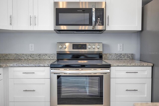 13493 SW 112th Pl, Dunnellon, FL 34432 - kitchen with stainless steel appliances, white cabinets, and light stone counters
