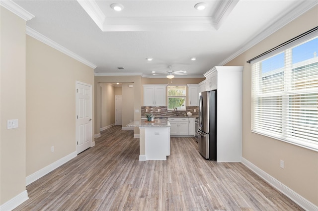 9923 SW 98th Ln, Ocala, FL 34481 - kitchen featuring white cabinets, freestanding refrigerator, decorative backsplash, and light wood-style floors
