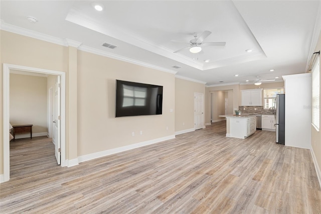 9923 SW 98th Ln, Ocala, FL 34481 - unfurnished living room with light wood-type flooring, a raised ceiling, and ceiling fan