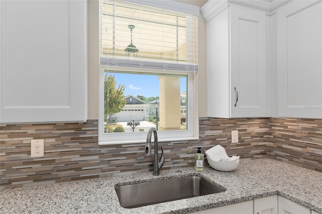 9923 SW 98th Ln, Ocala, FL 34481 - kitchen with light stone counters, a sink, white cabinetry, and decorative backsplash