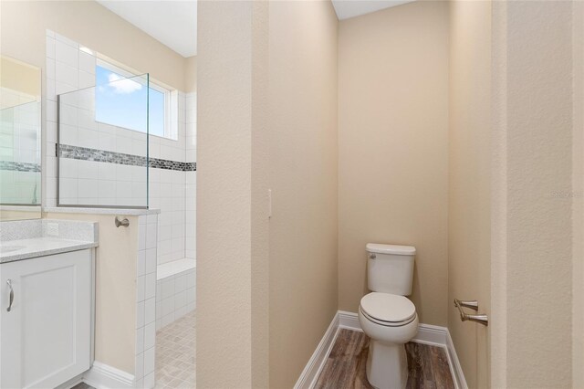 9923 SW 98th Ln, Ocala, FL 34481 - full bathroom with wood finished floors, a walk in shower, toilet, vanity, and baseboards