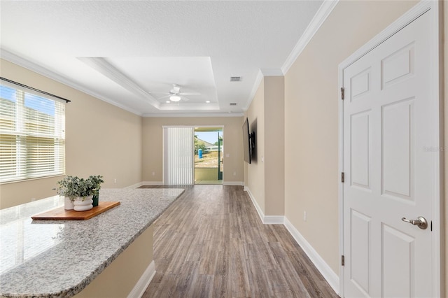 9923 SW 98th Ln, Ocala, FL 34481 - corridor featuring crown molding, a tray ceiling, baseboards, and light wood-style floors